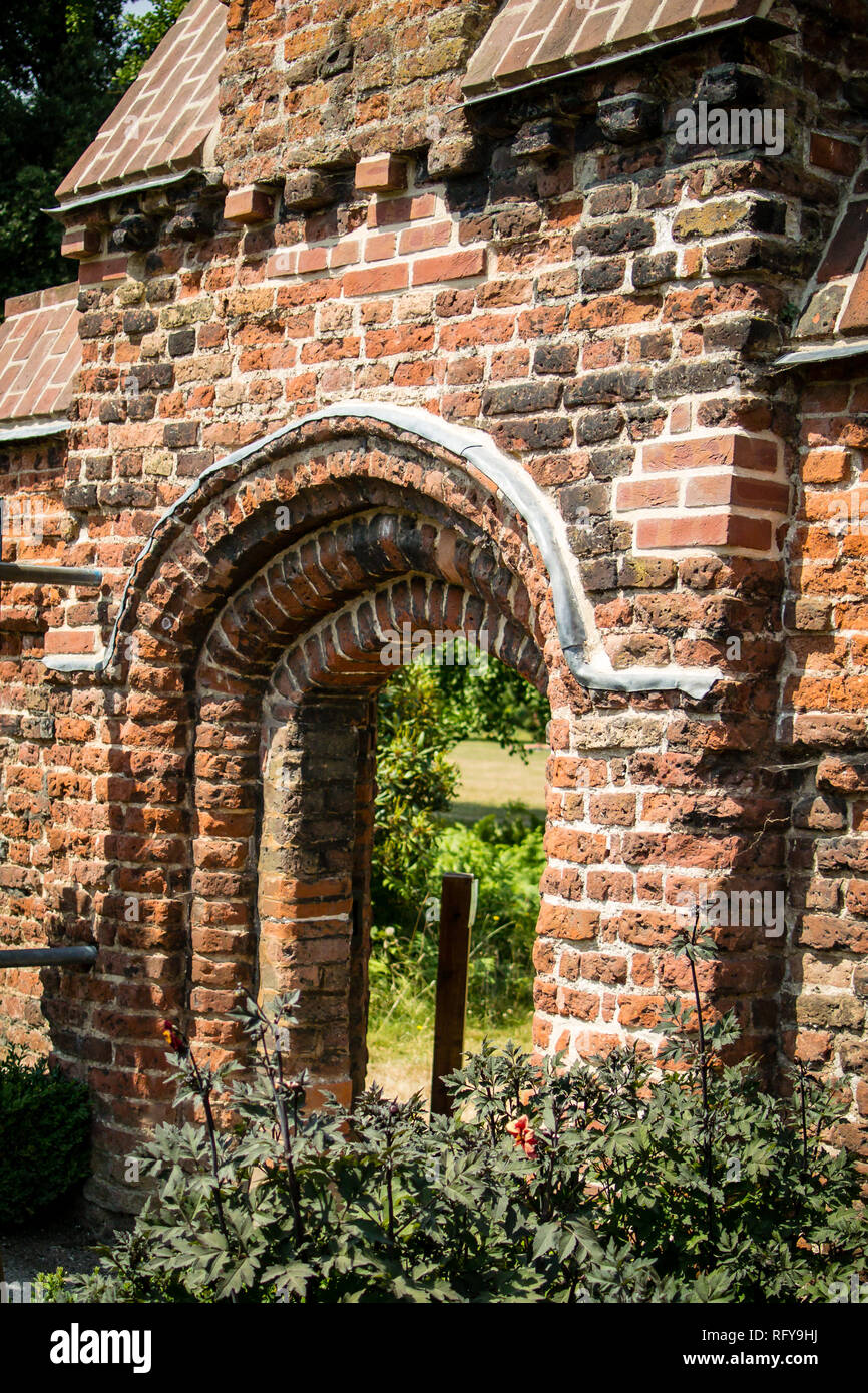 Red brick arch with stepped gable as access to the Tudor Walled Garden at the Bishop's Palace in Fulham, London Stock Photo