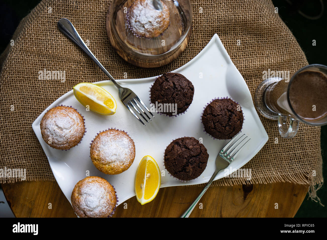 Tasty lemon and chocolate cupcakes in rustic interior Stock Photo