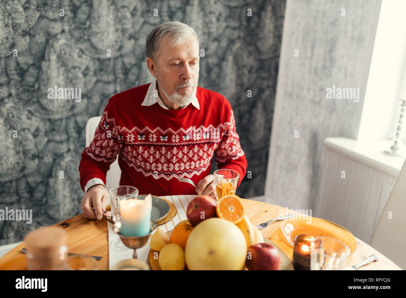 elegant smart bearded man eating in the kitchen room Stock Photo