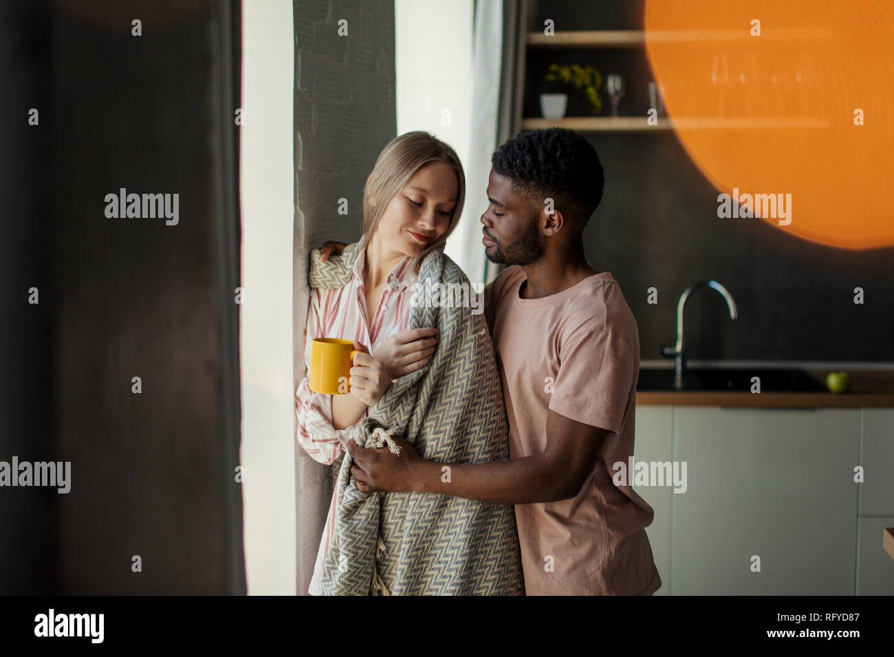 Loving black African young man hugs his caucasian wife. Stock Photo