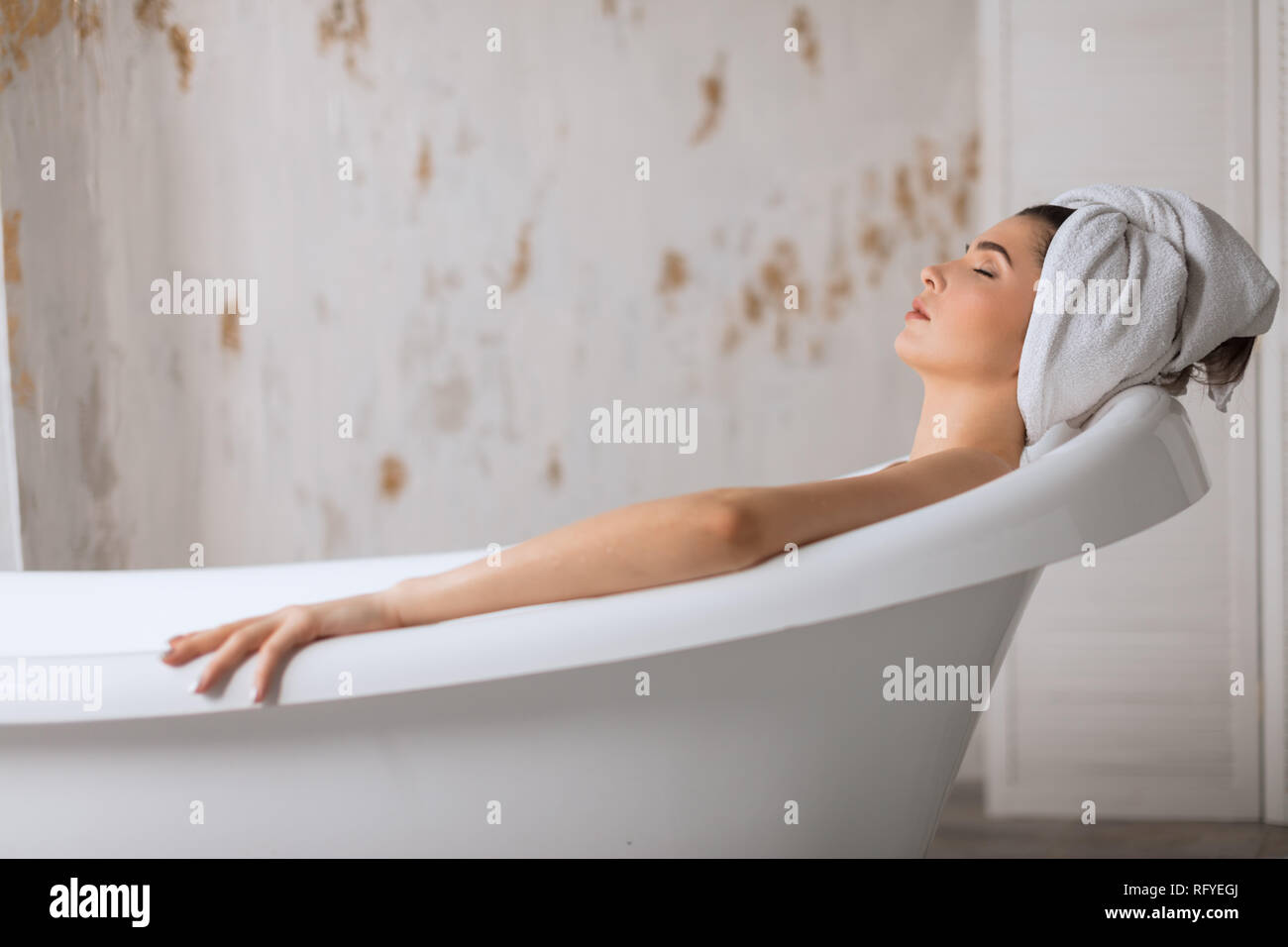 Relaxed young woman laying in bathtub Stock Photo Alamy