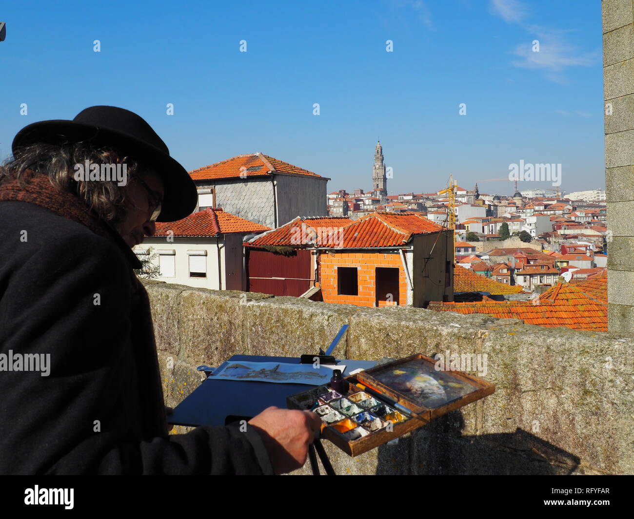 Street artist painting Porto skyline with Torre dos Clericos in the background - Porto - Portugal Stock Photo