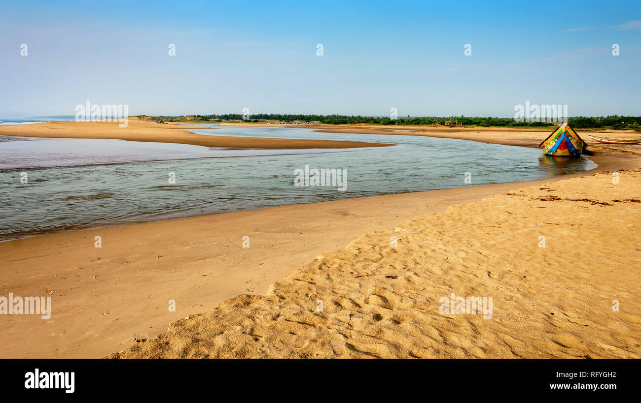 A traditional colourful fishing boat anchored at the confluence of Mahendra Tanaya river and Bay of Bengal, copy space Stock Photo