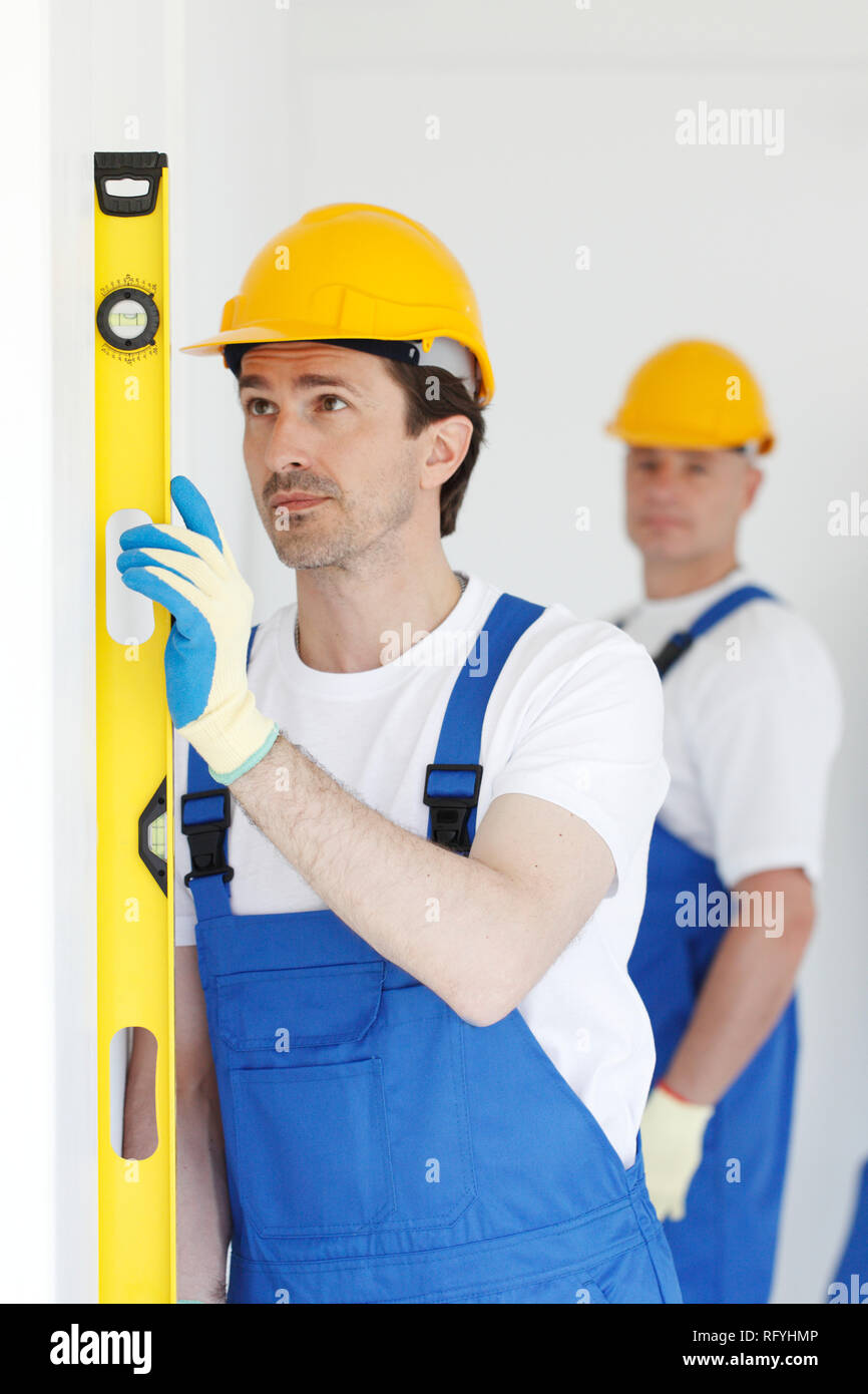 Team of workmen align wall using tools Stock Photo