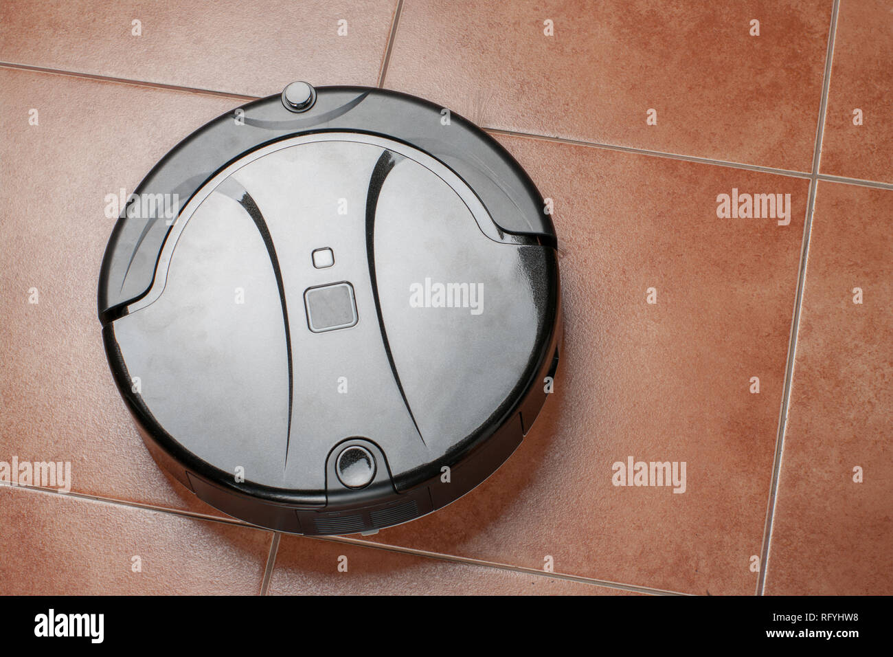 robotic vacuum cleaner working on tile floor. smart cleaning technology ...