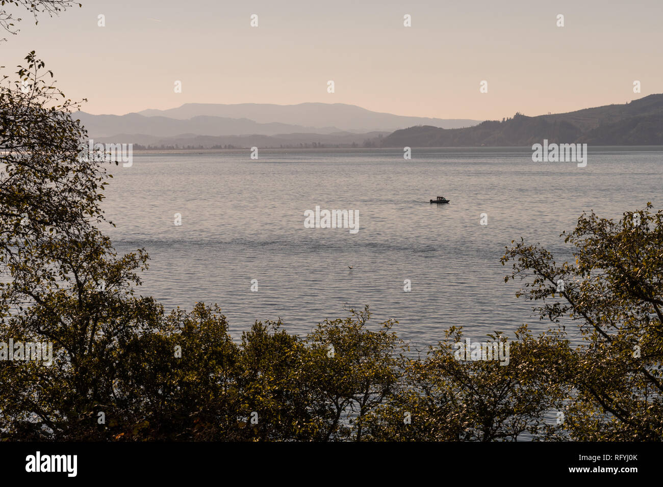Boat sailing at sunrise in Tillamook Bay off the coast of Oregon, USA