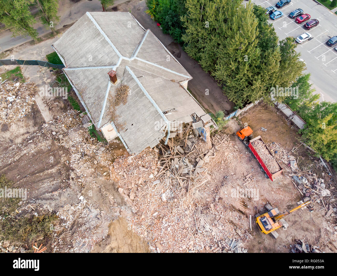 excavator and dump truck working at the demolition of an old derelict building. aerial view Stock Photo