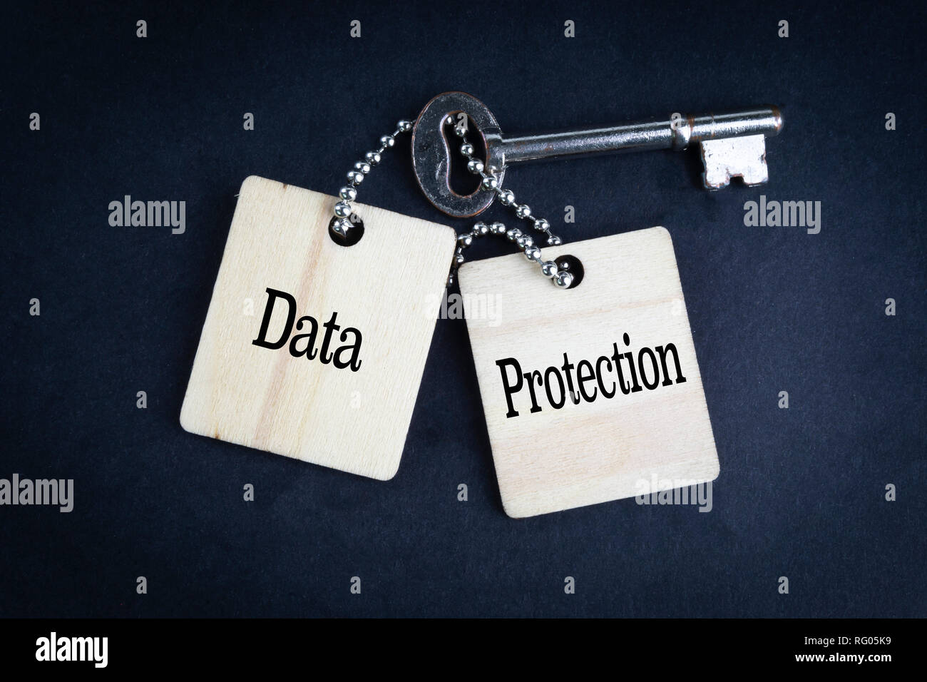 DATA PROTECTION inscription written on wooden tag and key on black background with selective focus and crop fragment. Business and education concept Stock Photo