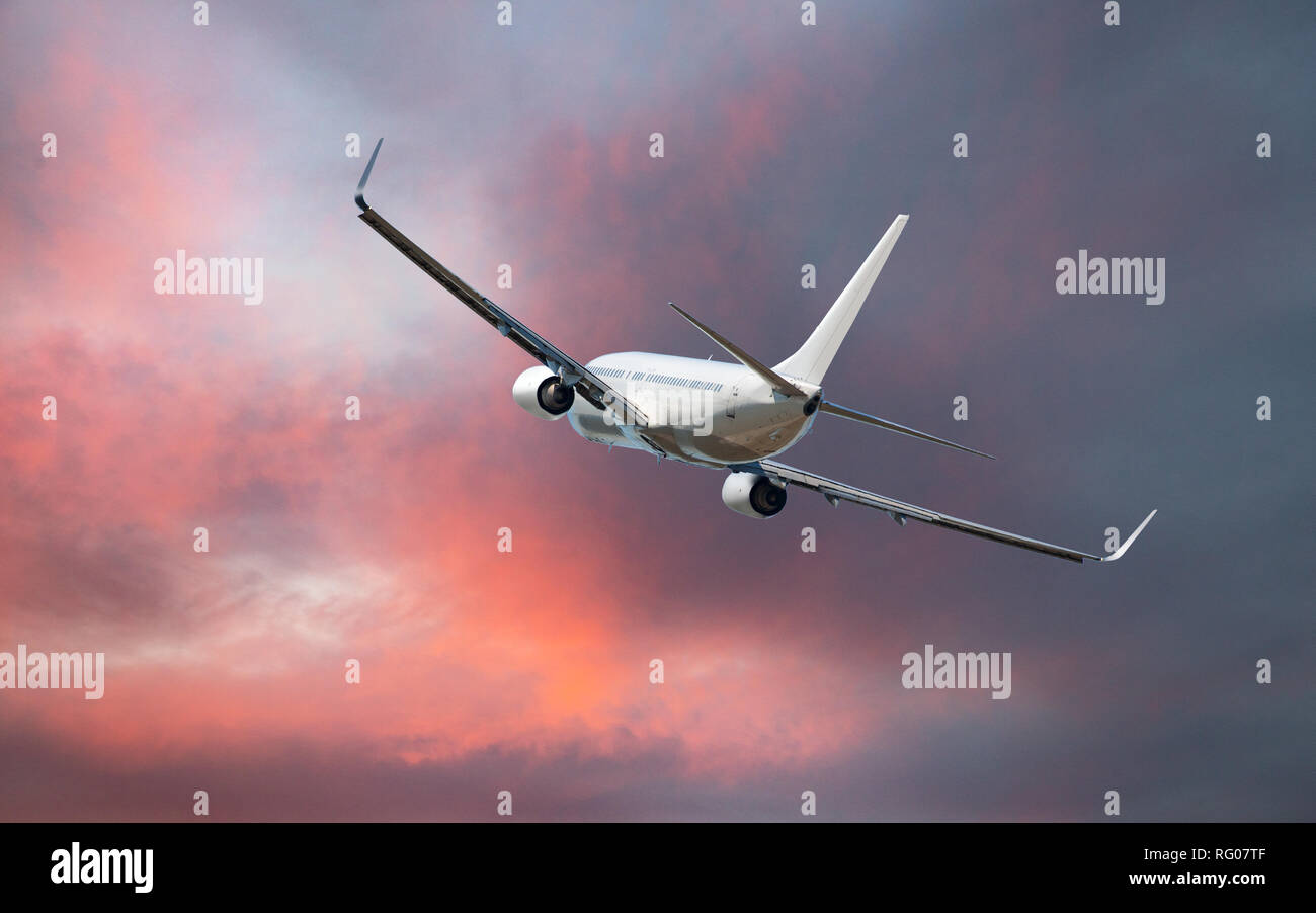 Commercial airplane flying above clouds in dramatic sunset light Stock ...