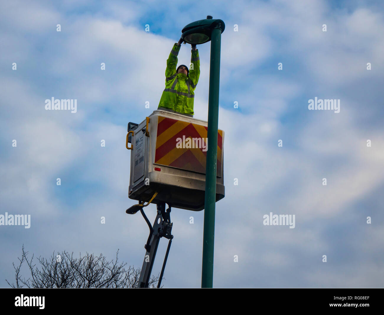 Man on an Hydraulic Hoist carrying out a repair on a street lamp post