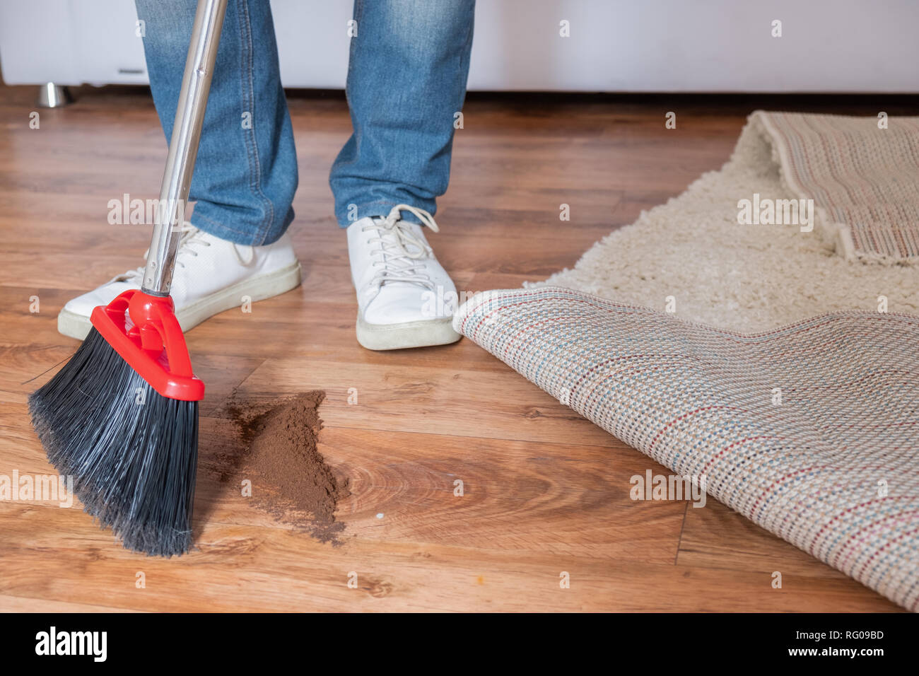 Housekeeping concept close up of broom sweeping floor at home Stock Photo