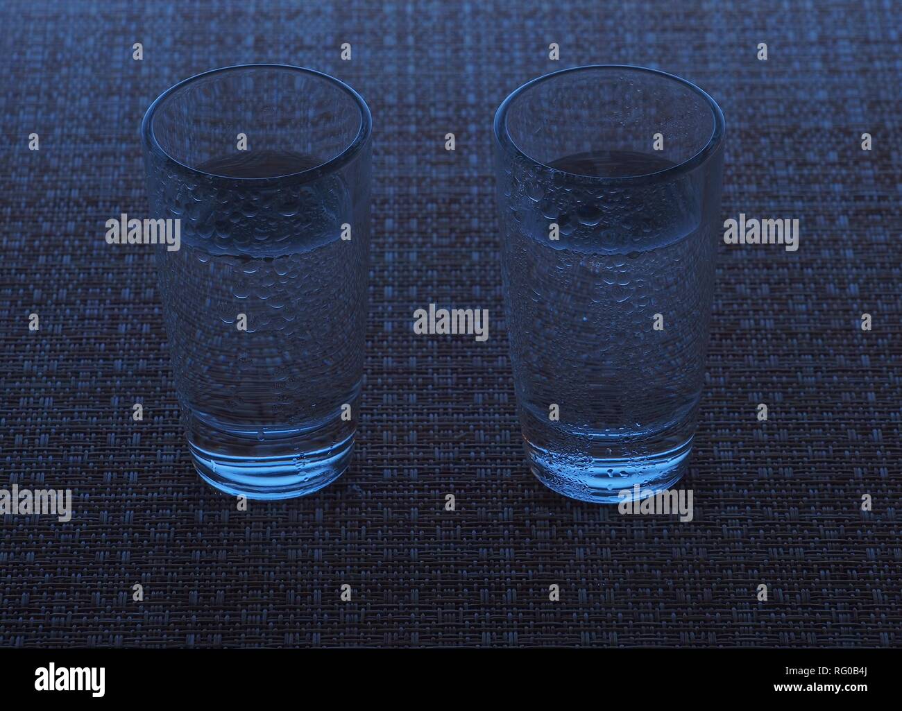 Two glasses of vodka are on the table. The glasses are covered with