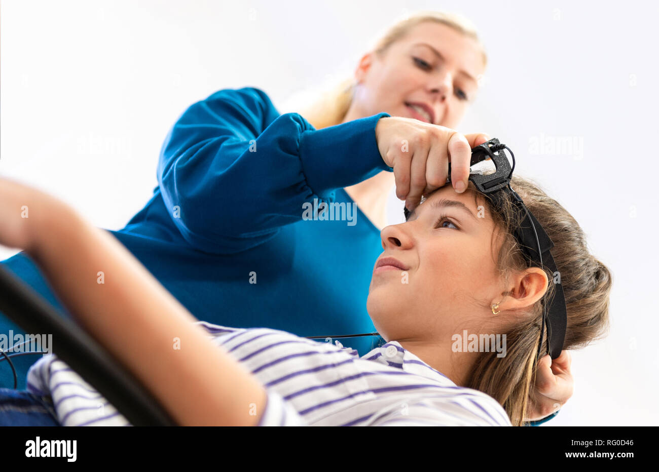 Young teenage girl and child therapist during EEG neurofeedback session. Electroencephalography concept. Stock Photo