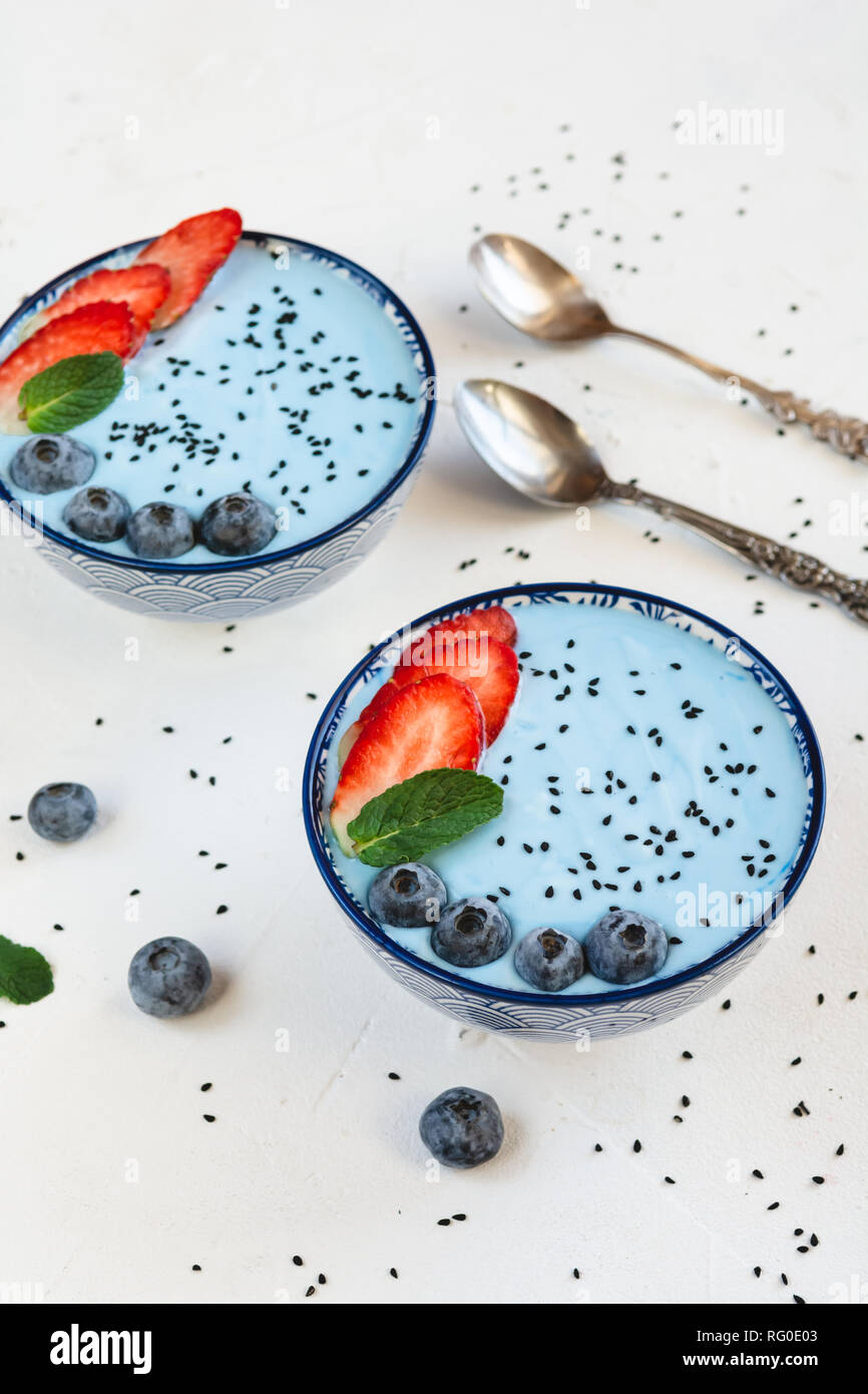 Blue yogurt smoothie made with blue spirulina powder, strawberries and blueberries. Stock Photo