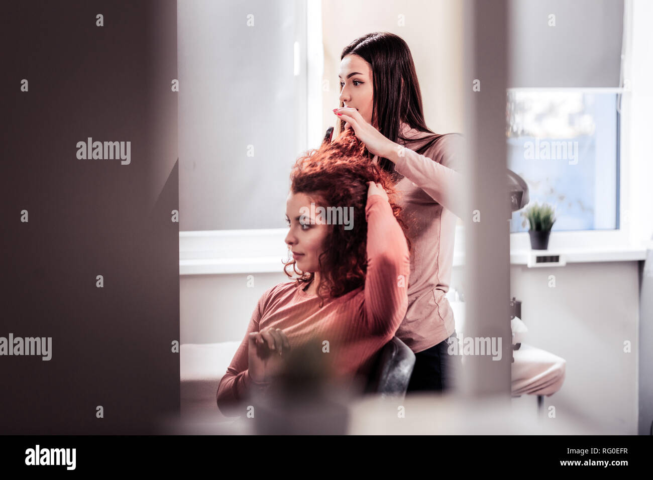 Nice young woman standing behind her client Stock Photo