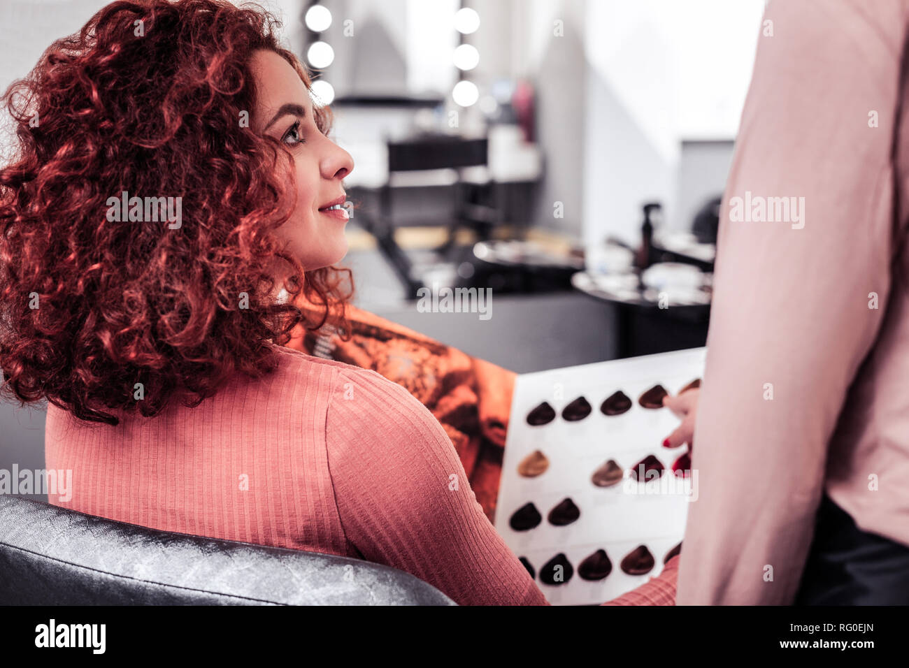 Nice red haired woman listening to her hairdresser Stock Photo