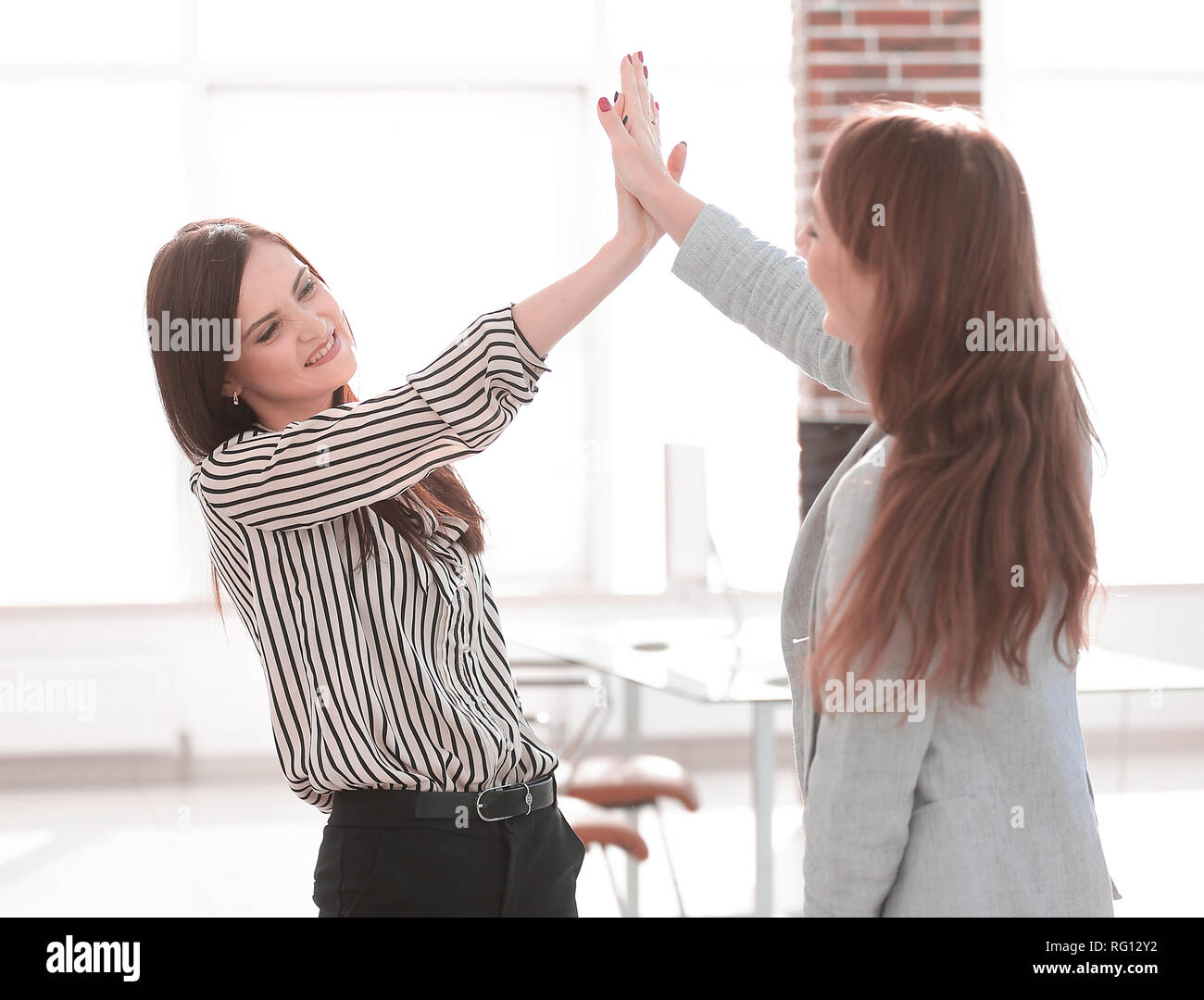 two young co-workers giving each other a high five Stock Photo - Alamy