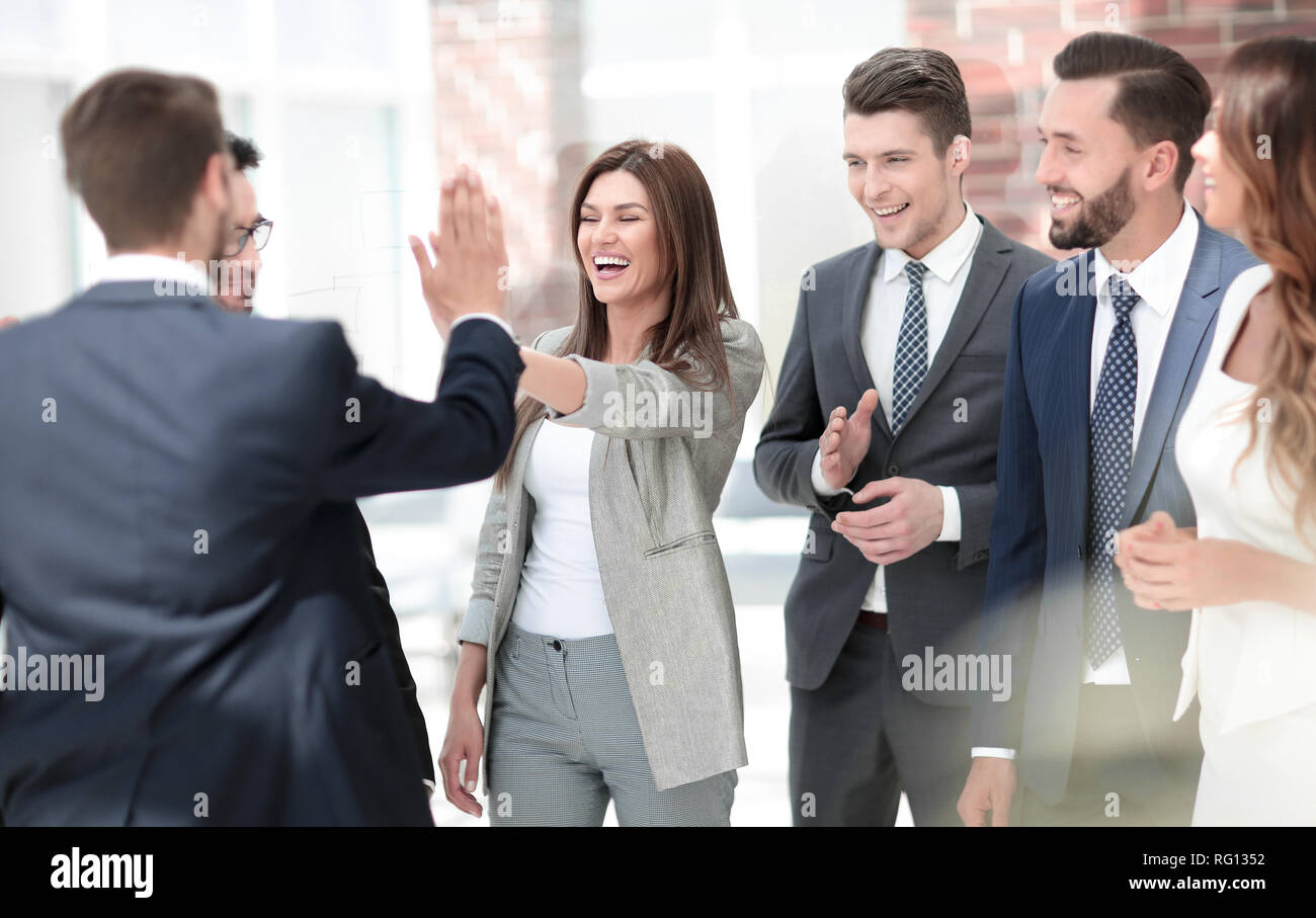 smiling business colleagues give each other a high five Stock Photo - Alamy