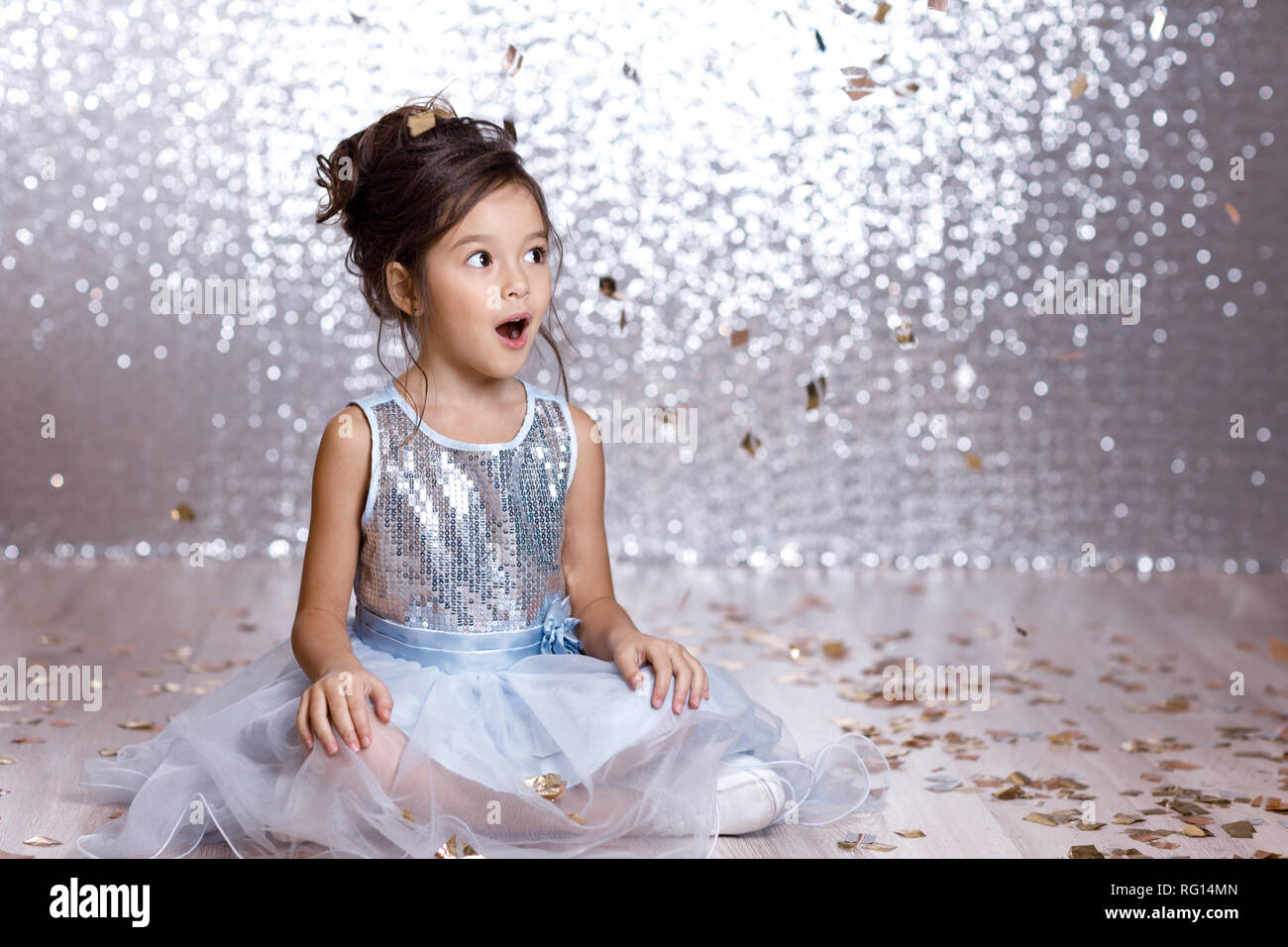 little girl in blue dress sitting on the floor with confetti Stock ...