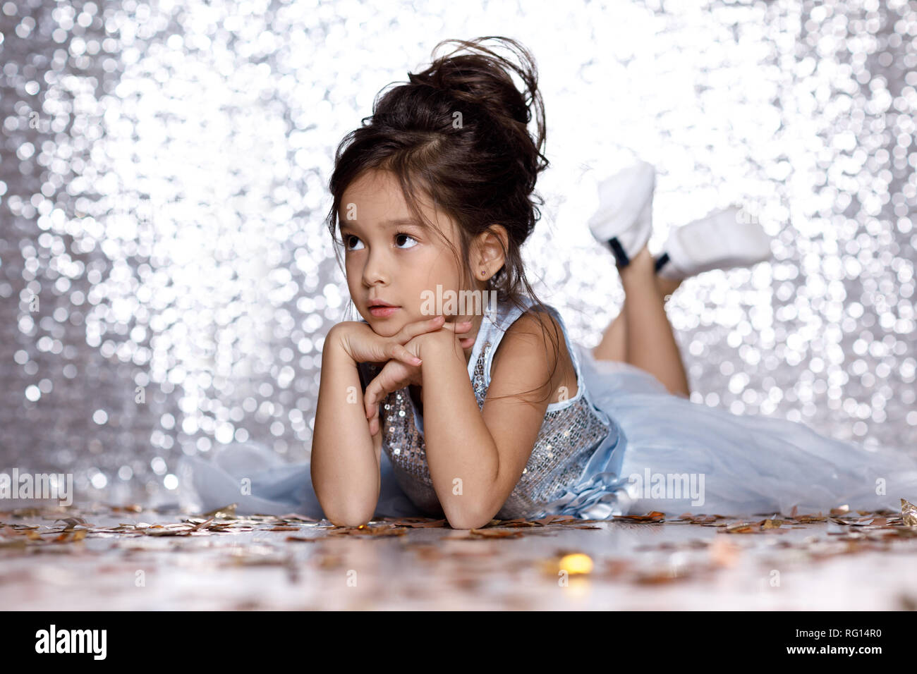 little girl in blue dress sitting on the floor with confetti Stock ...