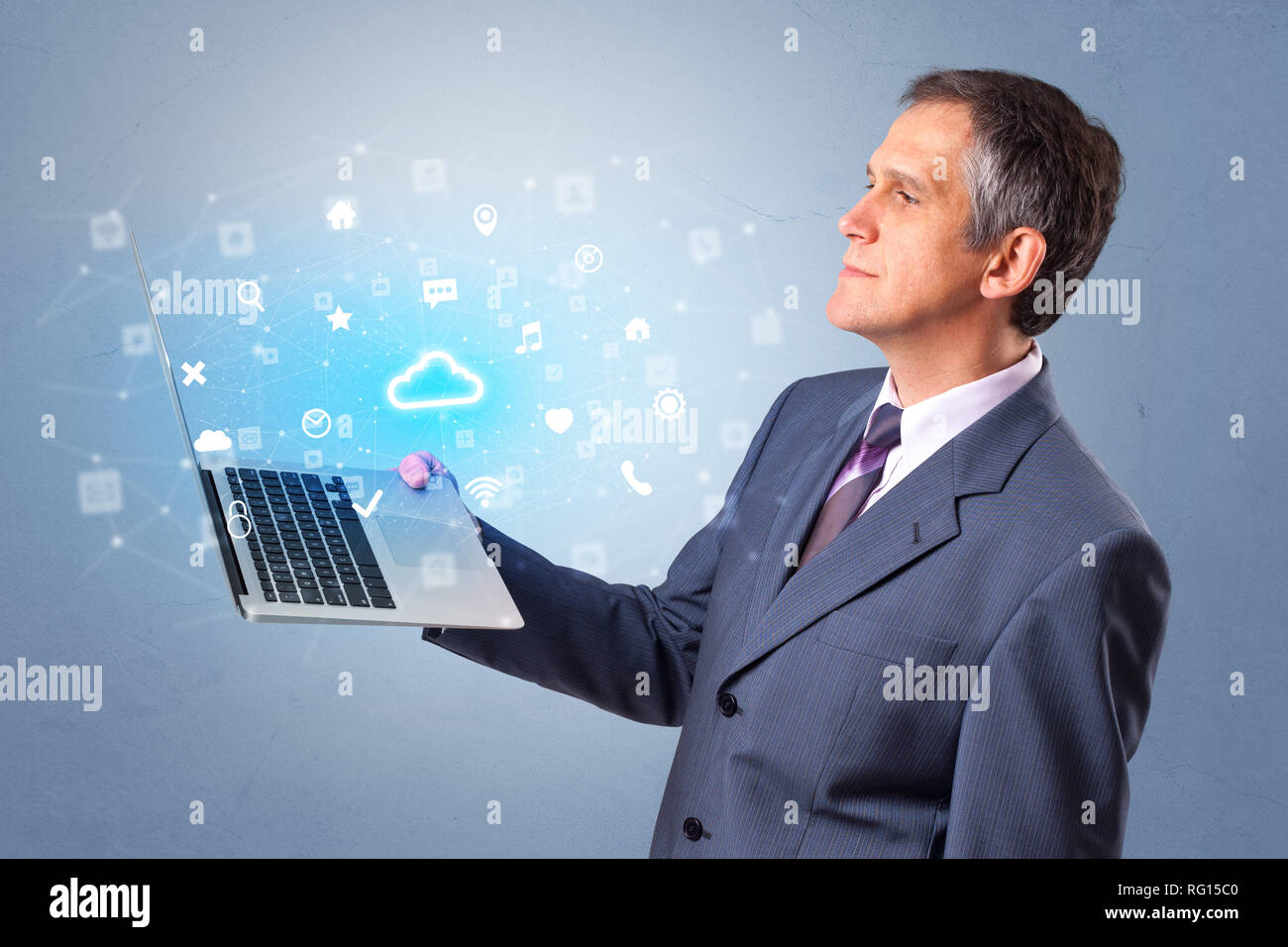 Man holding laptop projecting notifications, symbols and information based on cloud technology system Stock Photo