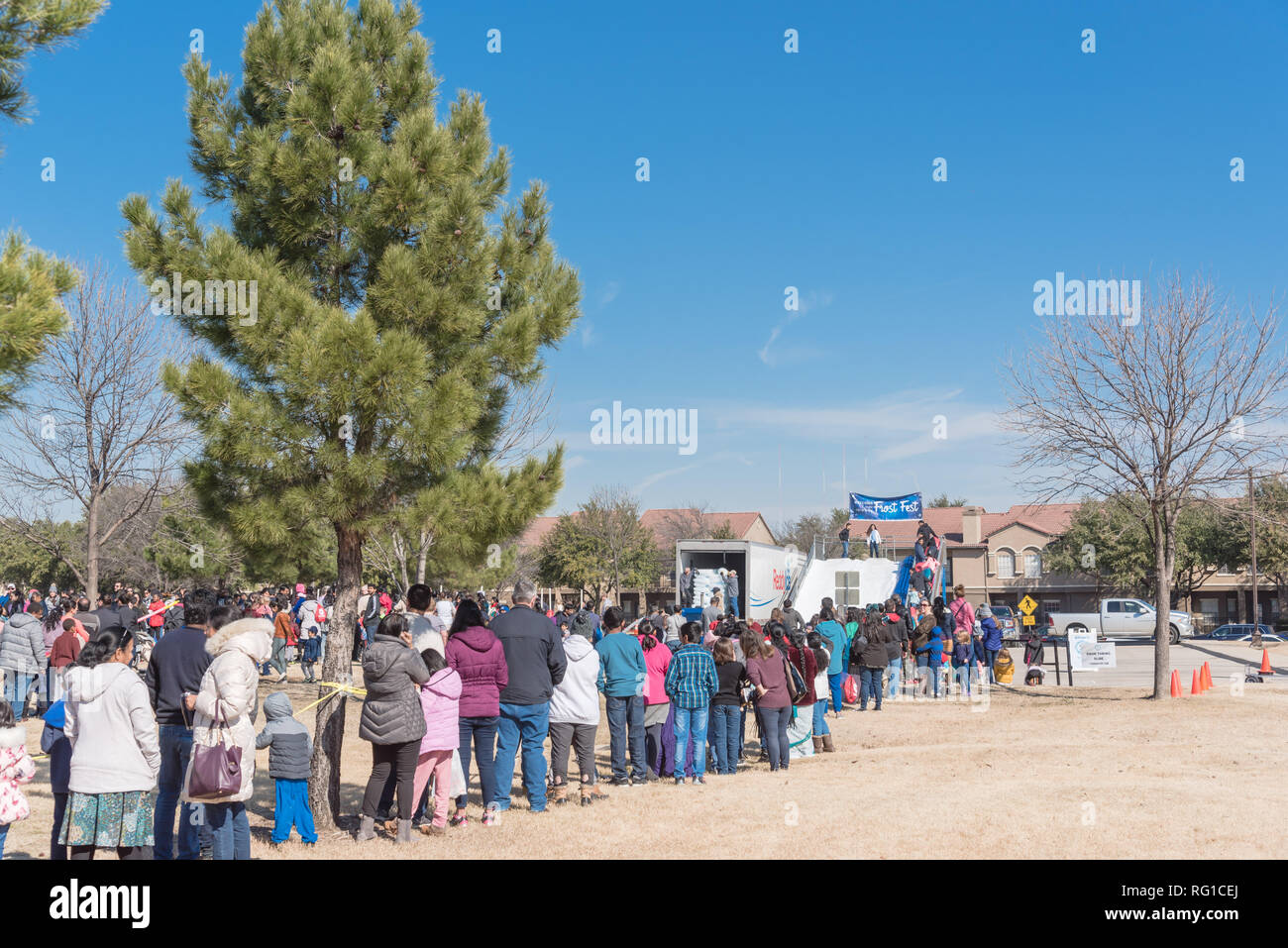 diverse-group-of-people-queue-in-line-to-attend-outdoor-winter-festival