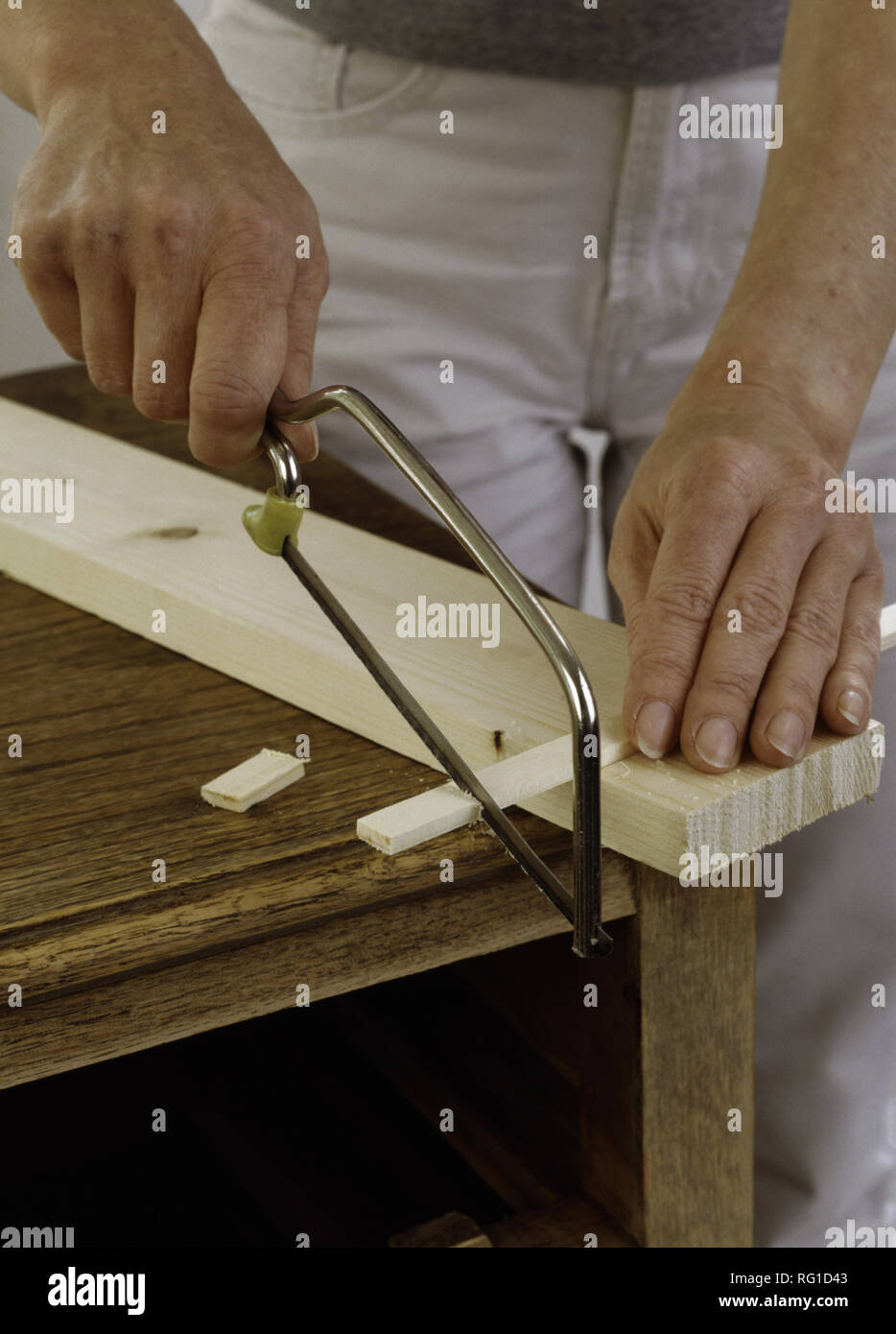 Hands cutting wood with a hacksaw Stock Photo Alamy
