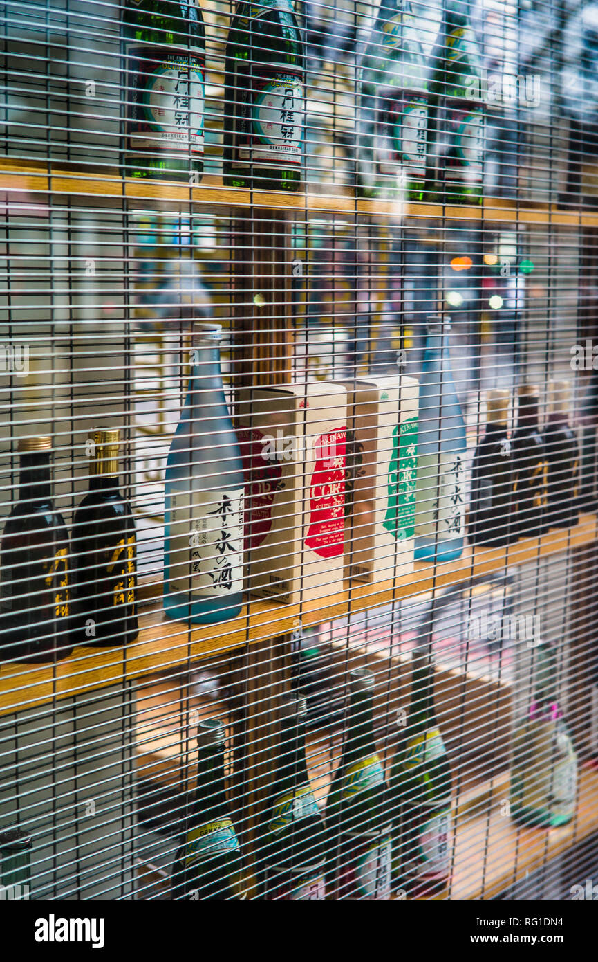 Sake bottles on display in the window of a  bar & restaurant in Shoreditch, Central London. London Sake bar. Stock Photo