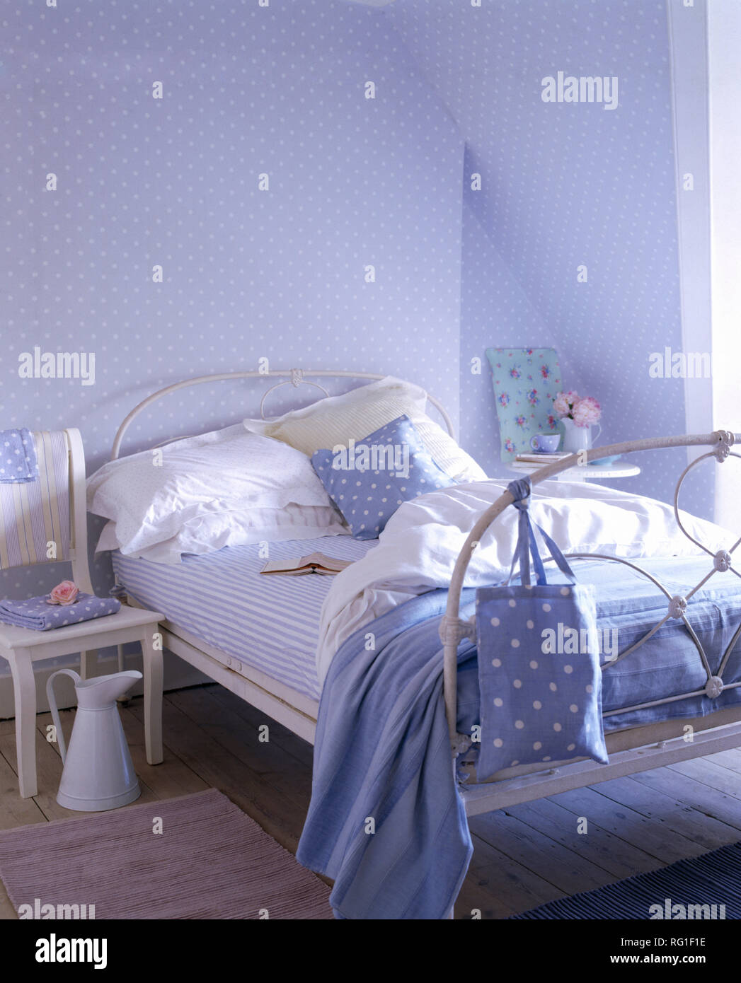 White wrought-iron bed in bedroom with blue wallpaper Stock Photo - Alamy