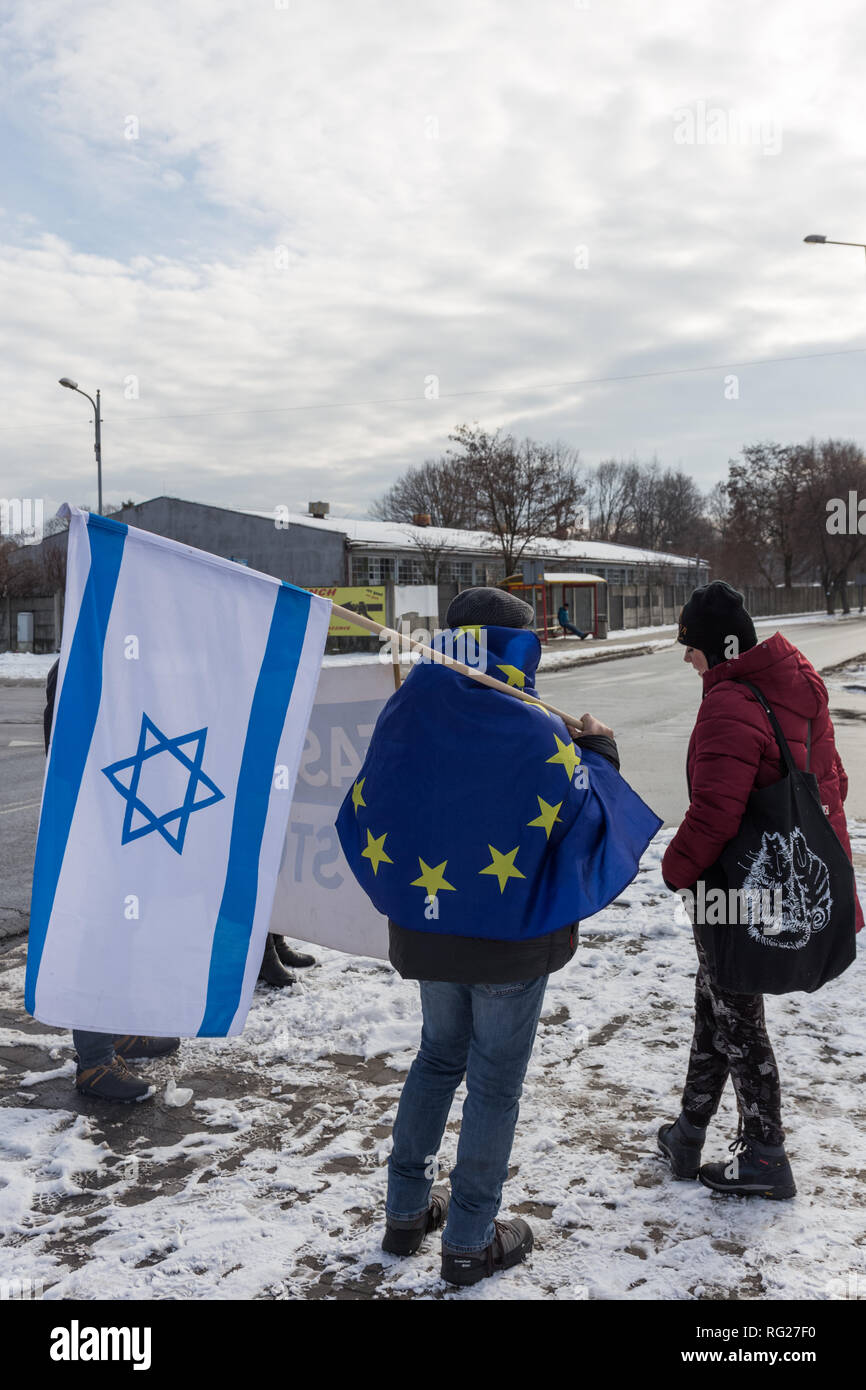 Oswiecim, Poland. 27th March, 2018. Holocaust Remembrance Day. Far right activists under the leadership of Piotr Rybak, earlier convicted for burning a figure of a Jew, organised march to the German Nazi Death Camp Auschwitz Birkenau supposedly to celebrate Polish victims of the death camp. In the picture: opposition activists holding EU and Israel flags protested against nationalism. Credit: Filip Radwanski/Alamy Live News Stock Photo