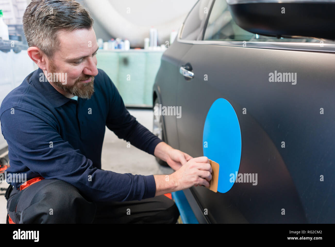 Man putting sticker with company slogan on a car Stock Photo Alamy