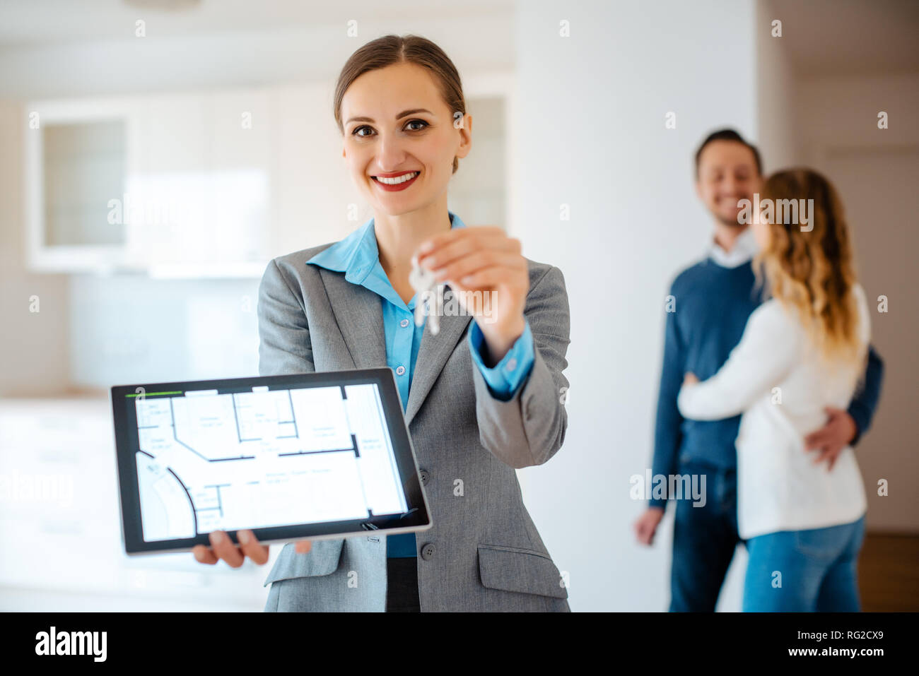 Realtor showing home keys and floorplan of apartment Stock Photo