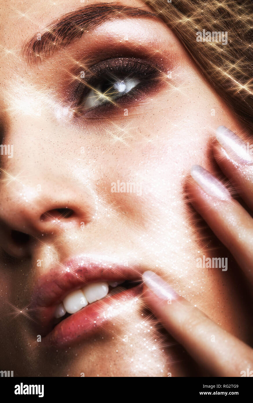 Portrait of beautiful young woman with vogue shining sparkle face makeup. Stock Photo