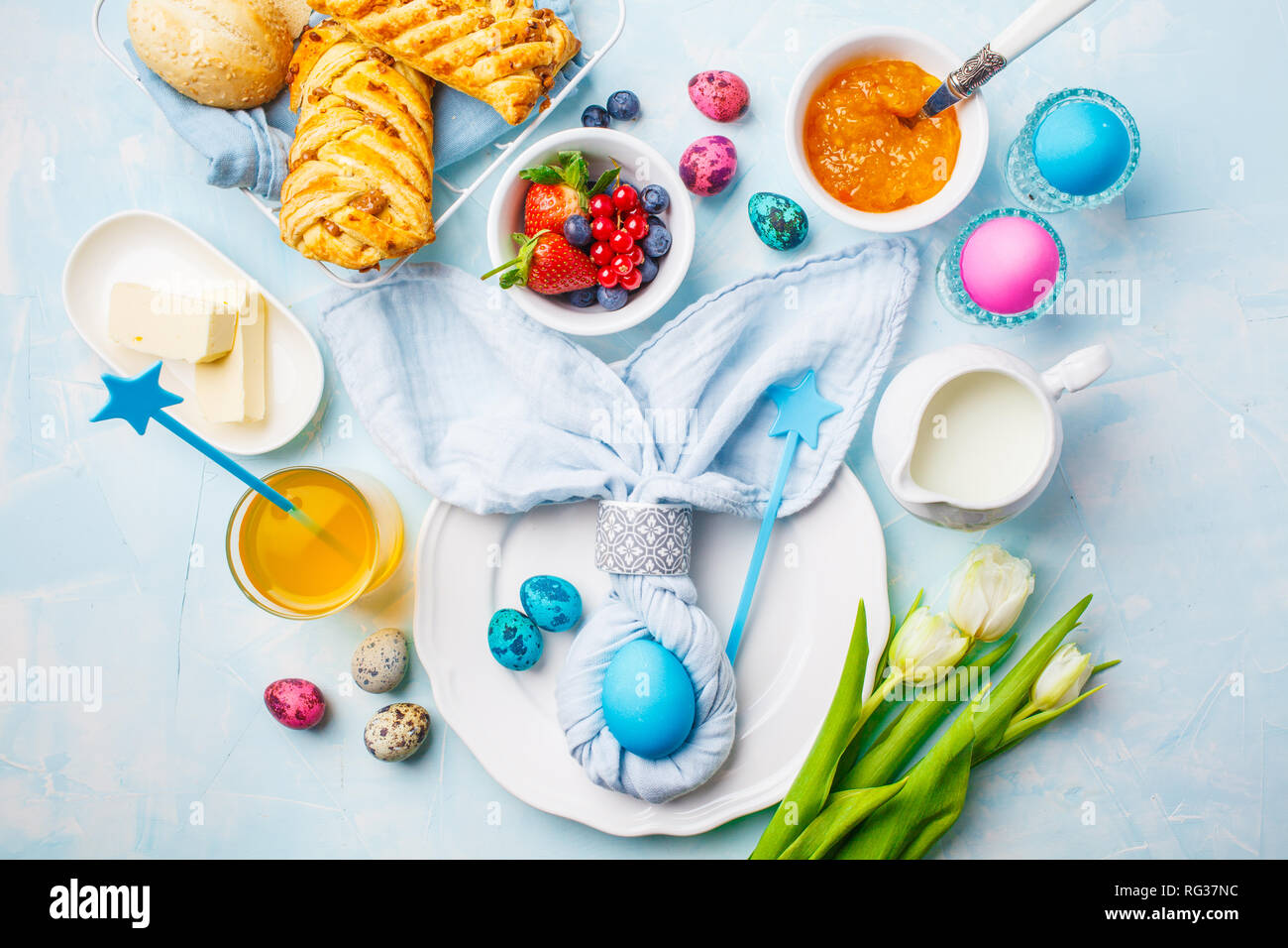 Easter Breakfast table. Blue background, festive table setting, top view. Stock Photo