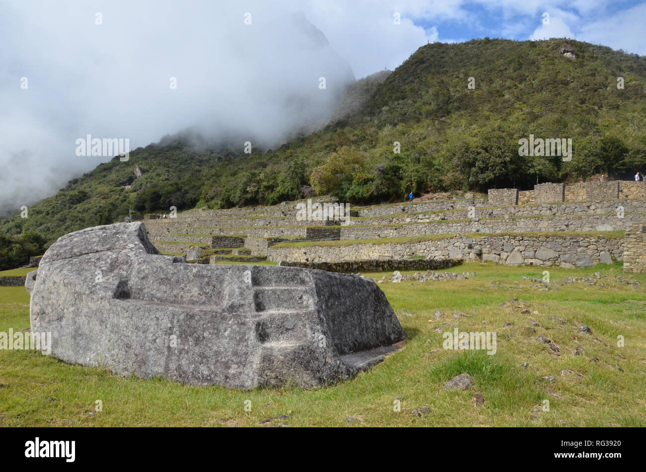 MACHU PICCHU / PERU, August 16, 2018: Visitors overlook the ceremonial rock at Machu Picchu Stock Photo