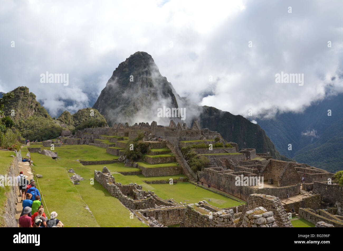 MACHU PICCHU / PERU, August 16, 2018: Tourists explore near the main plaza in Machu Picchu. Stock Photo