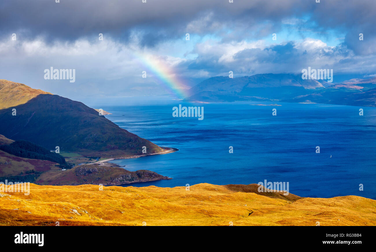 Dark clouds and heavy rain showers move in with a rainbow to follow looking accross  sea Loch Linnhe towards Fort William in the Scottish Highlands Stock Photo