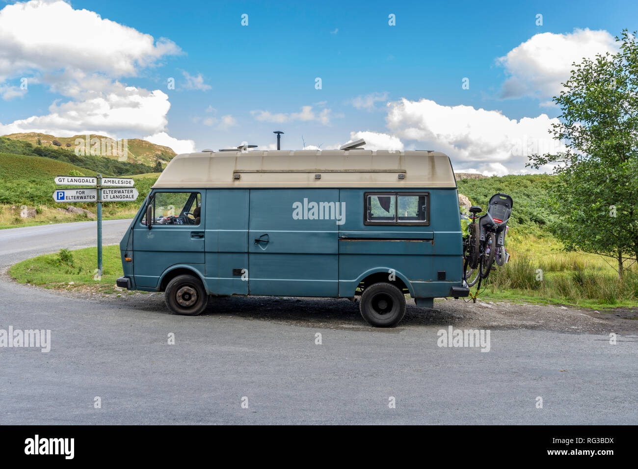 Mobile home  camper van parked in the  Lake District North West England UK Elterwater with fingerpost directions to Langdale Valley and Ambleide  with Stock Photo