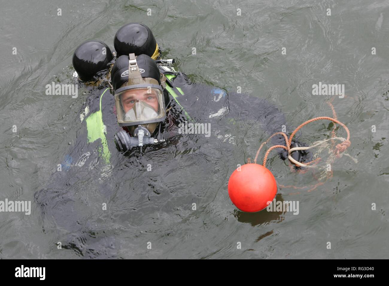 DEU, Federal Republic of Germany, Duisburg: Rescue diver of a fire brigade at the rescue of a barrel in the industriall port. Stock Photo