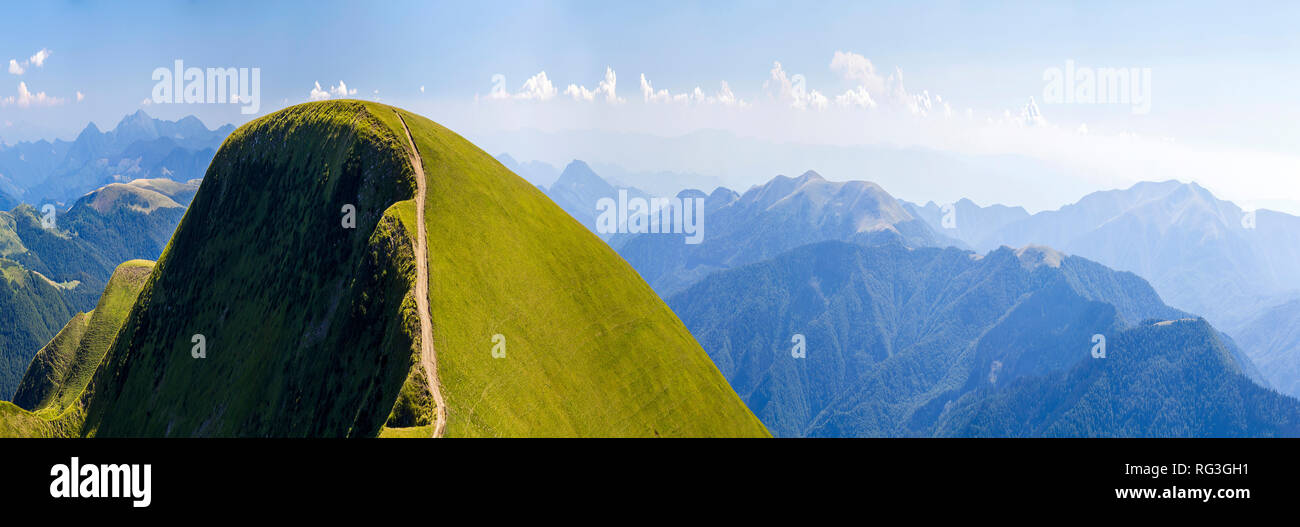 Panorama of green hills in summer mountains with gravel road for ...