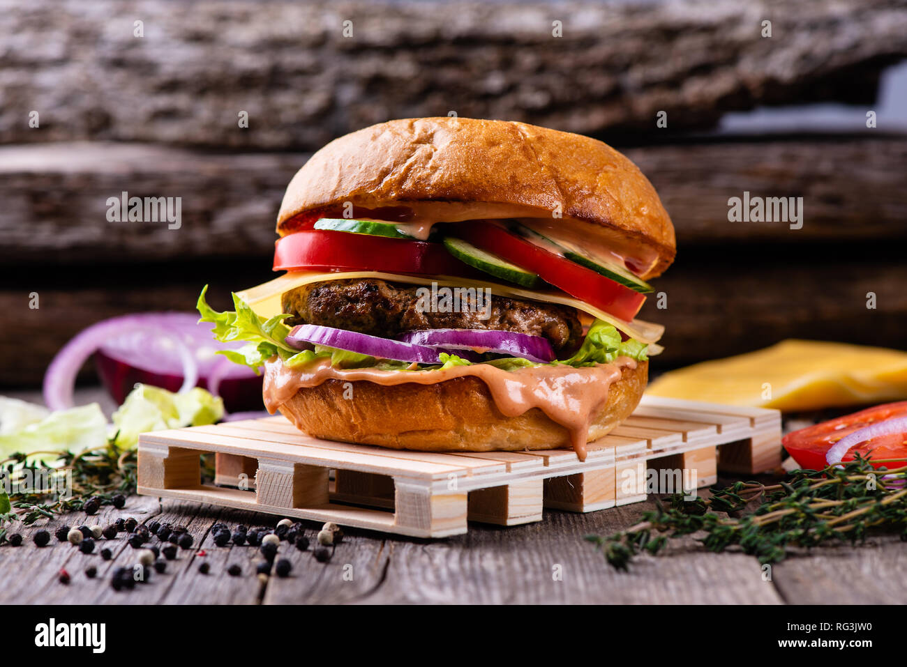 Fresh hamburger on aged wooden table, fast food. Vintage table and