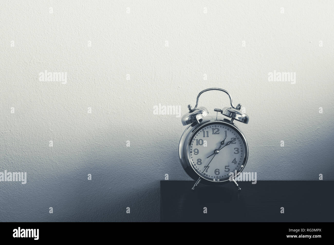 Retro alarm clock on table. Vintage style slate blue photo Stock Photo