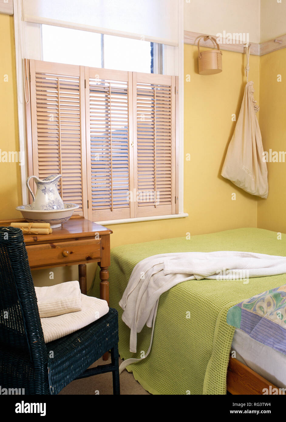 Plantation Shutters In Yellow Bedroom Stock Photo 233654656