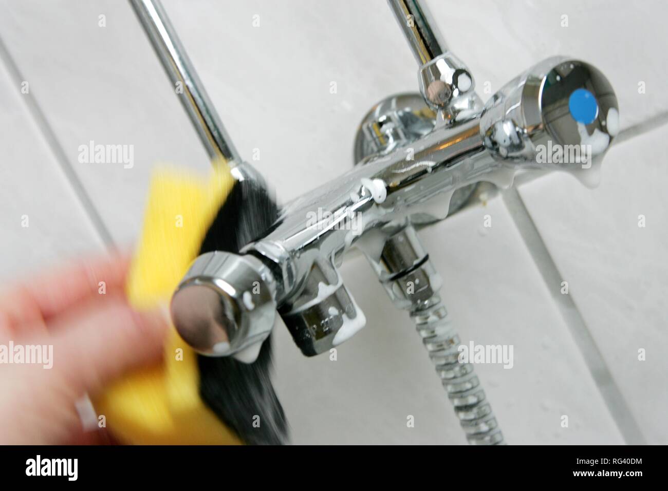 DEU, Germany : Housecleaning in a private house/apartment. Cleaning in the bathroom. Cleaning of the fittings. Stock Photo