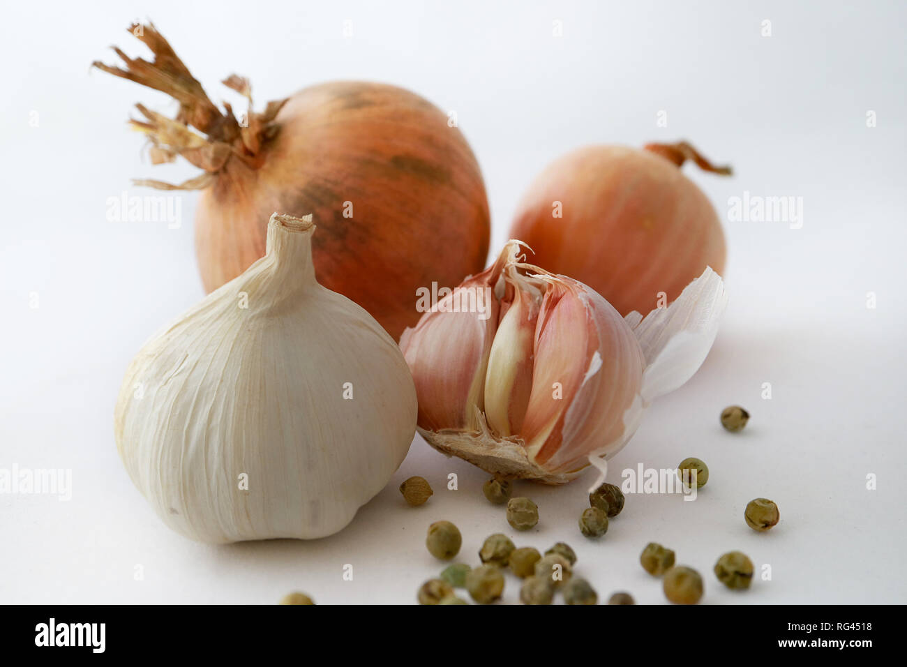 Cooking spices garlic, onion, and green pepper corns on white