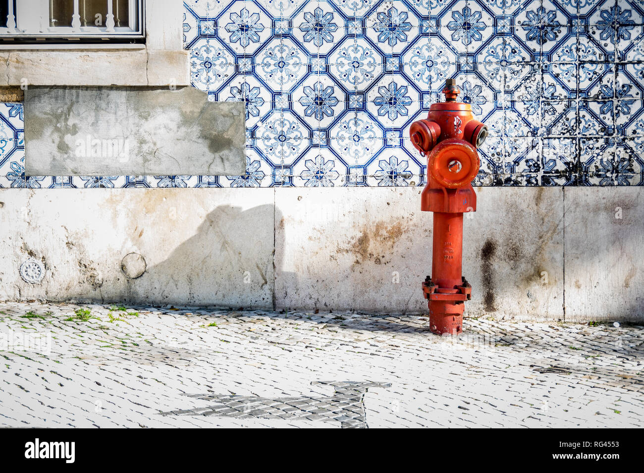 Red fire hydrant on a sidewalk in Lisbon Stock Photo