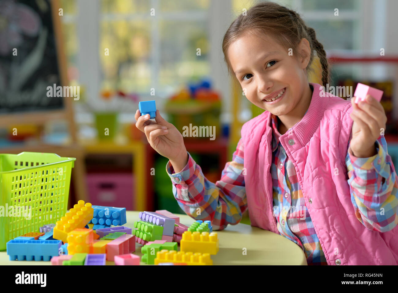 little girl playing with colorful plastic blocks Stock Photo - Alamy