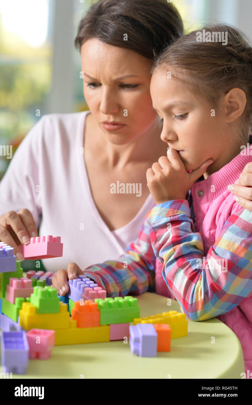 girl and her mother playing with colorful plastic blocks Stock Photo ...