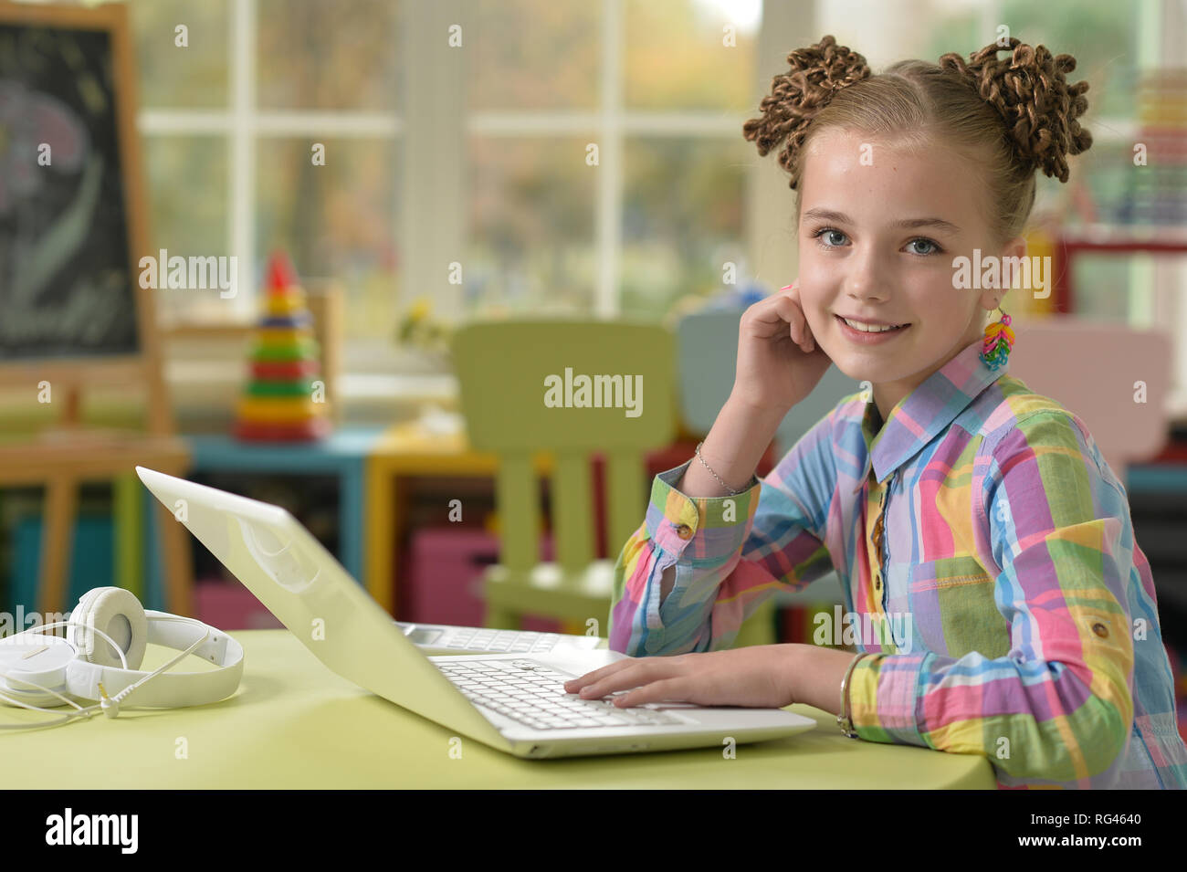 Portrait of cute little girl using laptop Stock Photo - Alamy