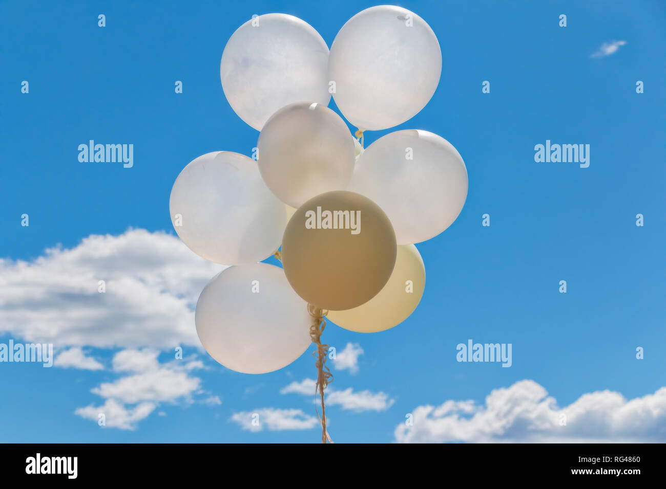 group of white balloons against blue summer sky with clouds Stock Photo